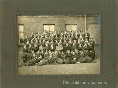K. Apkalnes sieviešu ģimnāzijas audzēknes un skolotāji; otrajā rindā no kreisās puses 6. - Kristīne Apkalne, ap 1911. gadu. Foto "Brāļi Matīsi Rīgā un Cēsīs" - CM 59104