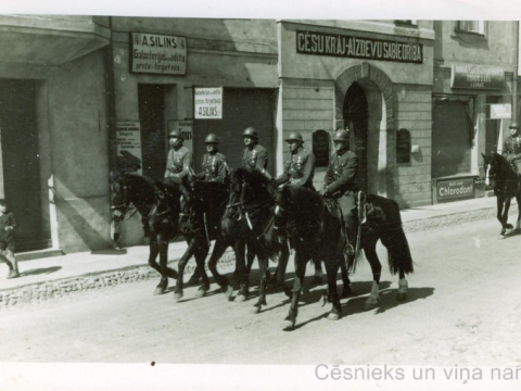 Karavīri zirgos pie Cēsu Krājaizdevu sabiedrības nama Rīgas ielā 4, 20. gs. 20. gadu vidus; CM 56359