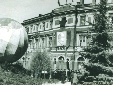 Pie nama Cēsīs, L. Katrīnas ielā 2 padomju okupācijas varas simbolika un vairāki cilvēki 1. maijā, starptautiskajā darbaļaužu solidaritātes dienas mītiņā 1941.gadā.