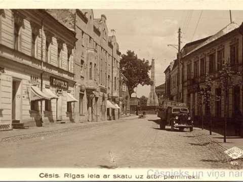 Nams Rīgas ielā 4, pie M. Radziņa veikala skatloga piestiprināta Valsts elektrotehniskās fabrikas (VEF) reklāma, 20. gs. 30. gadi; CM 112898